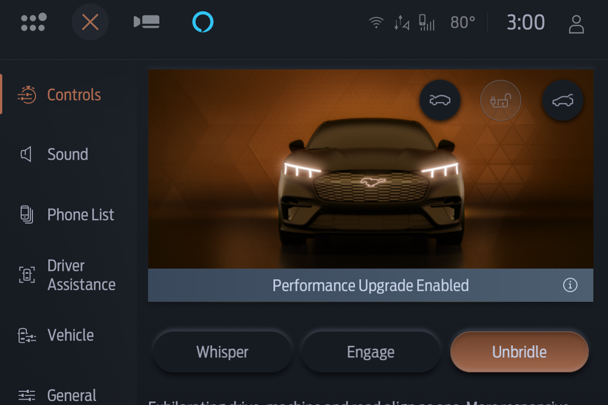 A Mustang Mach-E® driving down a city road at night.