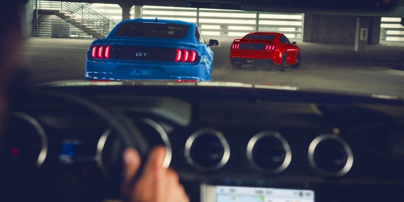 Photo of two 2024 Ford Mustang's driving on the road