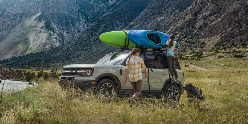 Photo of people grabbing a kayak on a 2024 Ford Bronco Sport