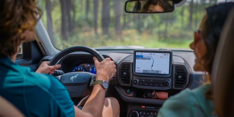 Interior view of people using GPS in a 2024 Ford Bronco Sport
