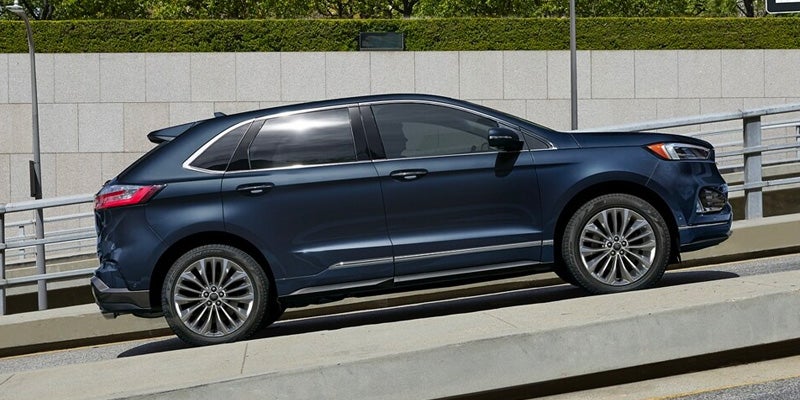 Side view of a 2024 Ford Edge driving up a inclined road
