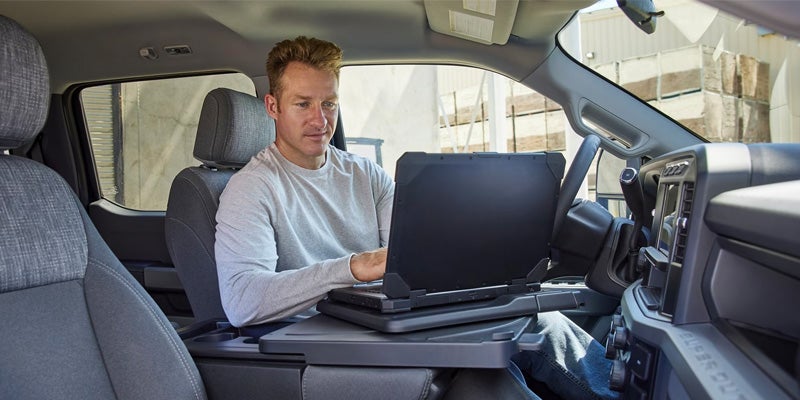 Photo of person on their laptop inside of a 2024 Ford Super Duty