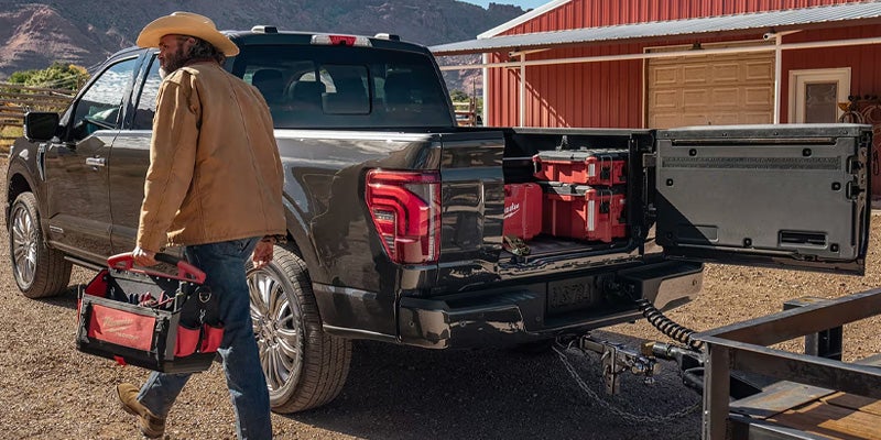 Photo of a person grabbing tools from a 2025 Ford F-150